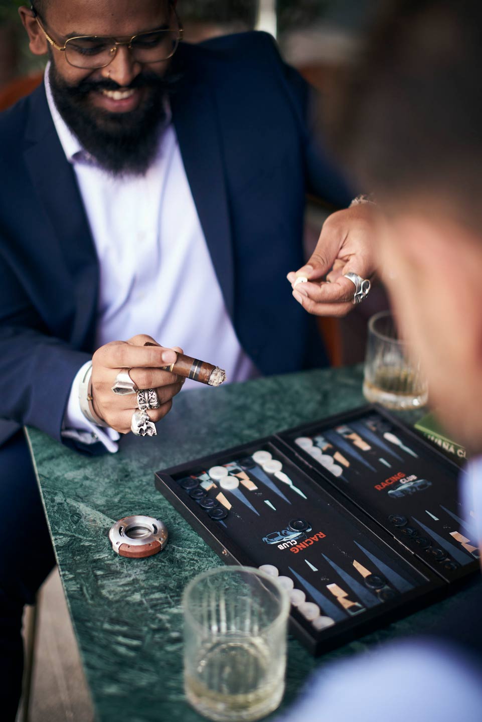 Lifestyle photography of man holding cigar playing backgammon