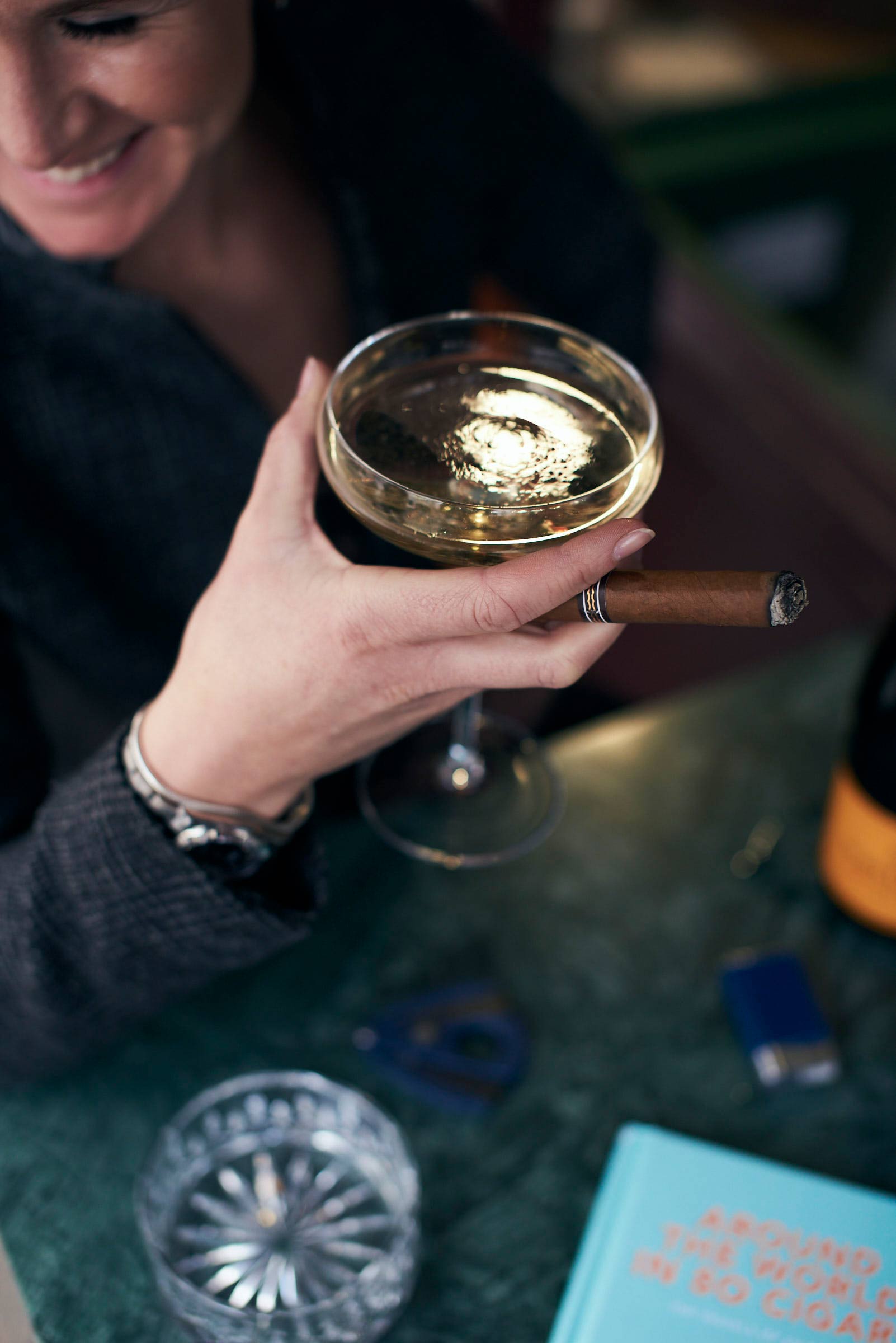 Lifestyle photography of woman holding cigar and champagne