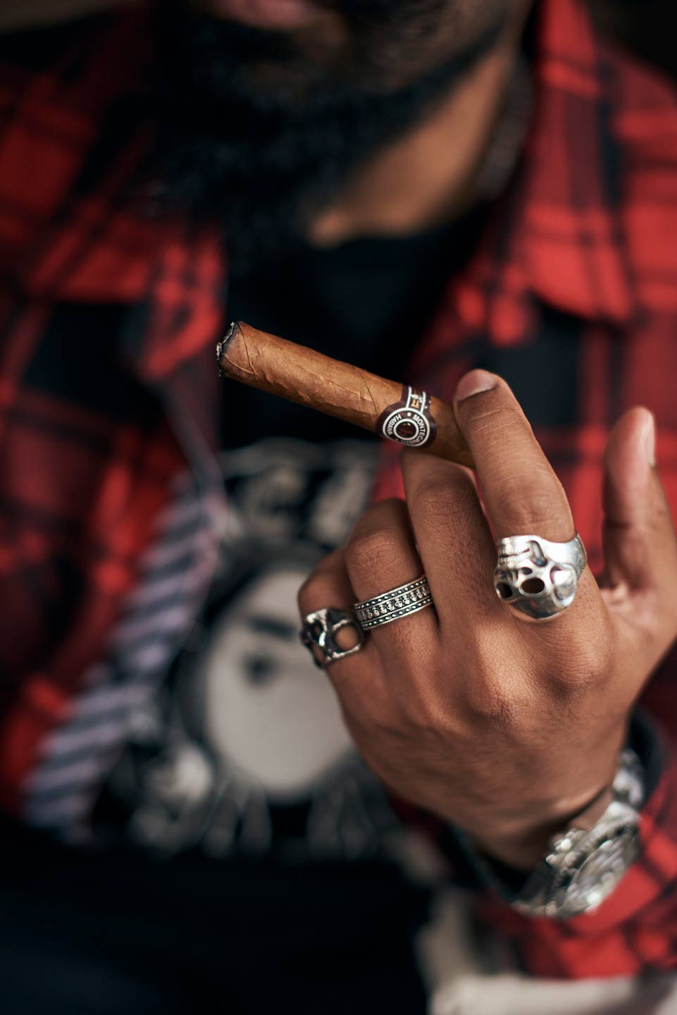 Lifestyle photography of man's hand holding cigar with rings