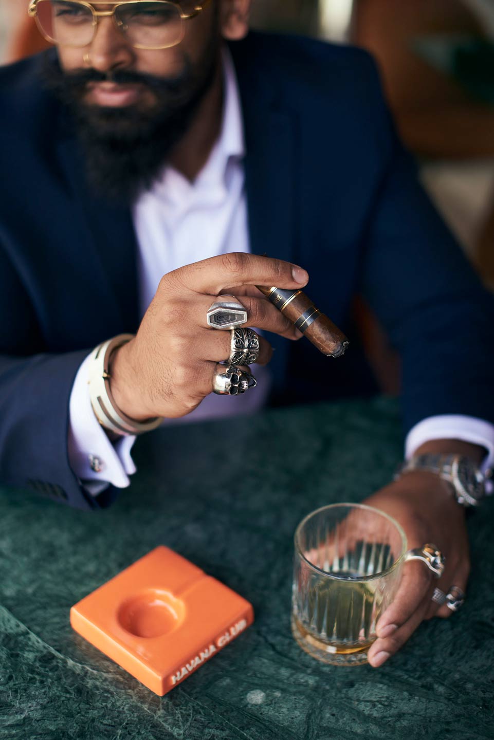 Lifestyle photography of man holding cigar and drinking whisky